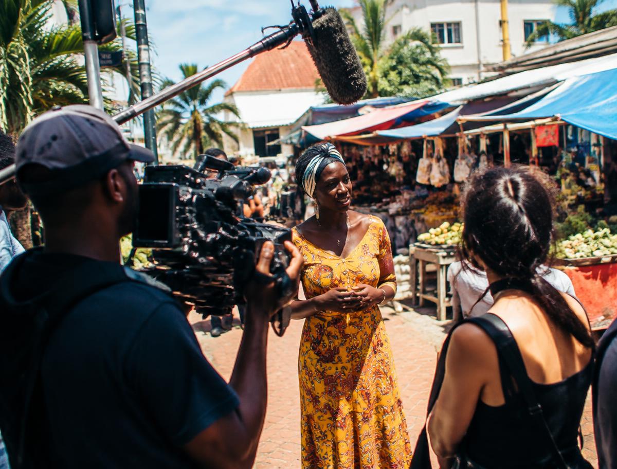 Film crew on set with camera and lighting